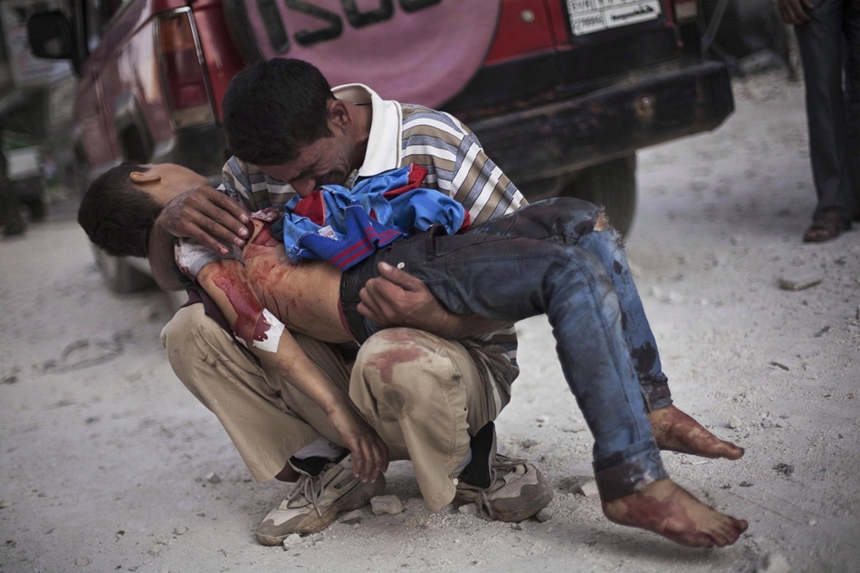Halott fiát tartja karjaiban egy szír férfi az aleppói Dar as-Sifa kórház közelében.
