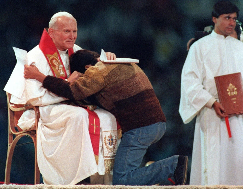 1987. április 2. - Santiago, Chile: Fredy Ormeño, a fiatalok számára rendezett szabadtéri mise egyik résztvevőjének könnyei II. János Pál mellkasán