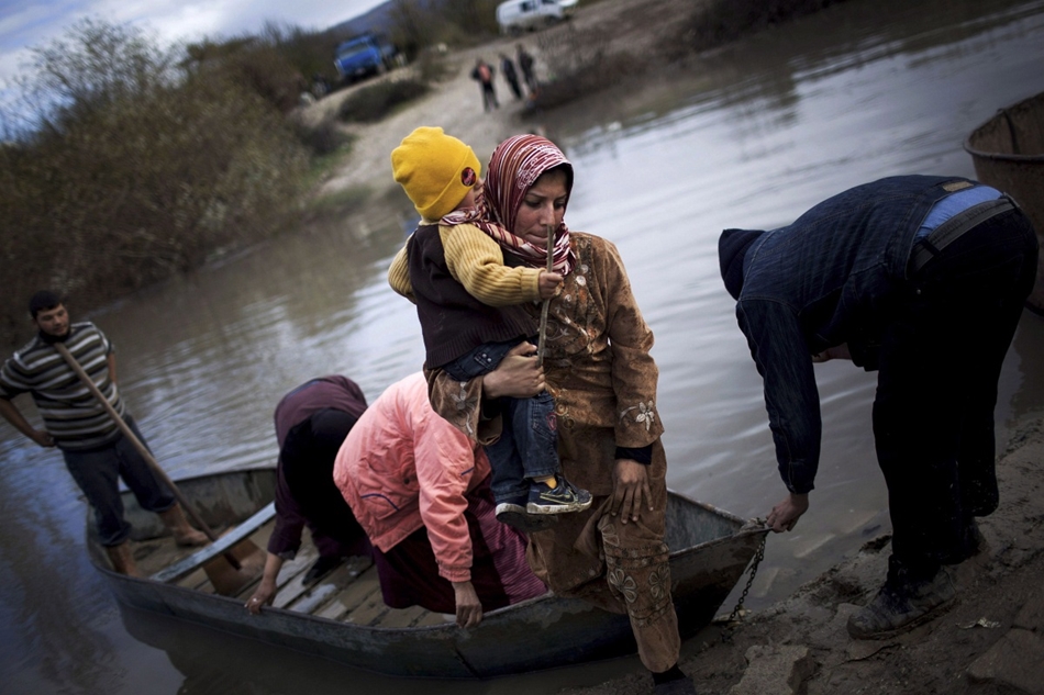 Szíriai menekültek csónakon érkeznek az Orontes folyón a törökországi Hacipasába.